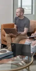 Employees with laptops attending a meeting